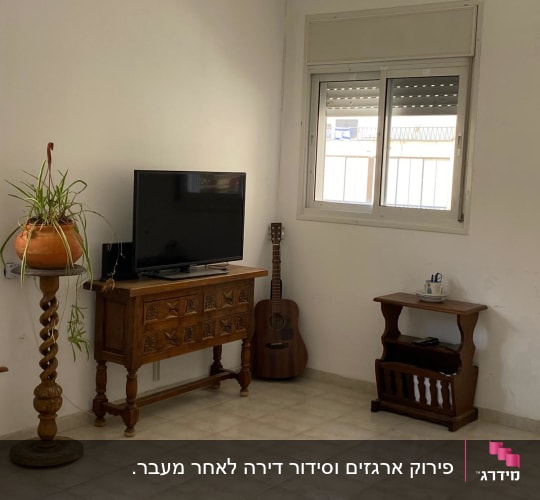 טלוויזיה על שידה מעץ, גיטרה בצד